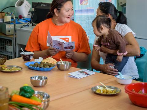 World Vision staff with mother and child